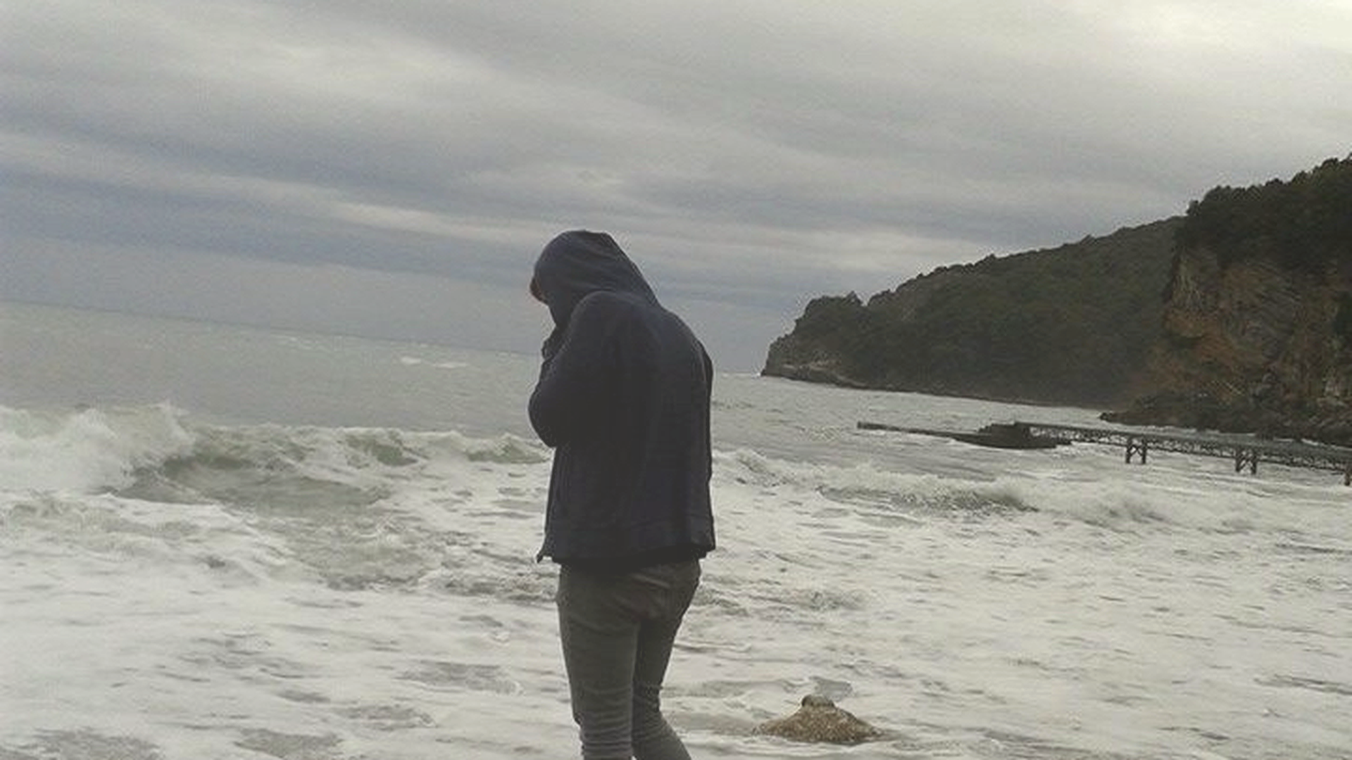 Person am Meer bei bewölktem Himmel – Symbolbild für Hypervigilanz, innere Wachsamkeit und das Thema Nervensystem und Kontrolle.